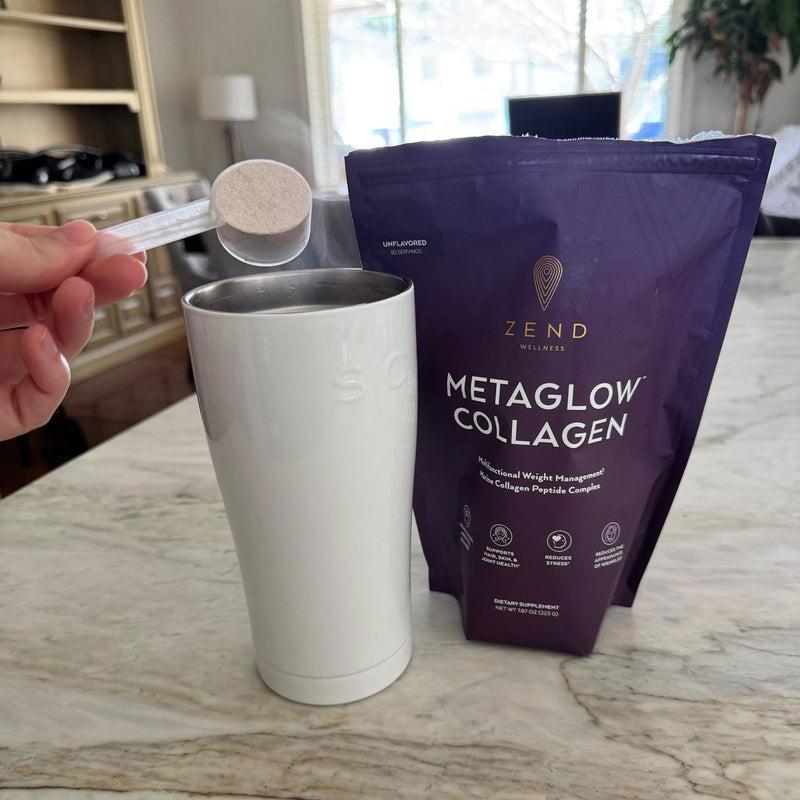 A scoop of MetaGlow going into a cup of coffee
