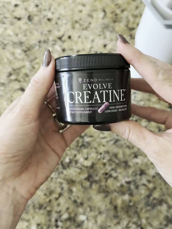 Woman with Evolve Creatine in her kitchen