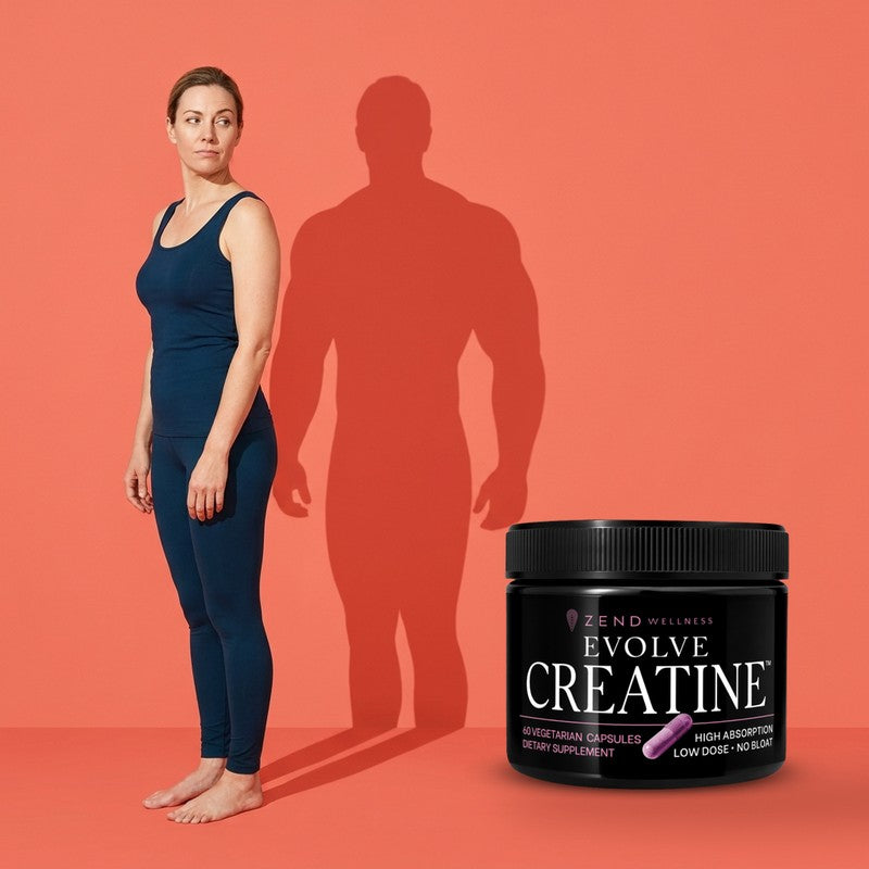 A woman looking, unimpressed, at her own cast shadow, which is twice her width and heavily built, with the Evolve Creatine jar beside her