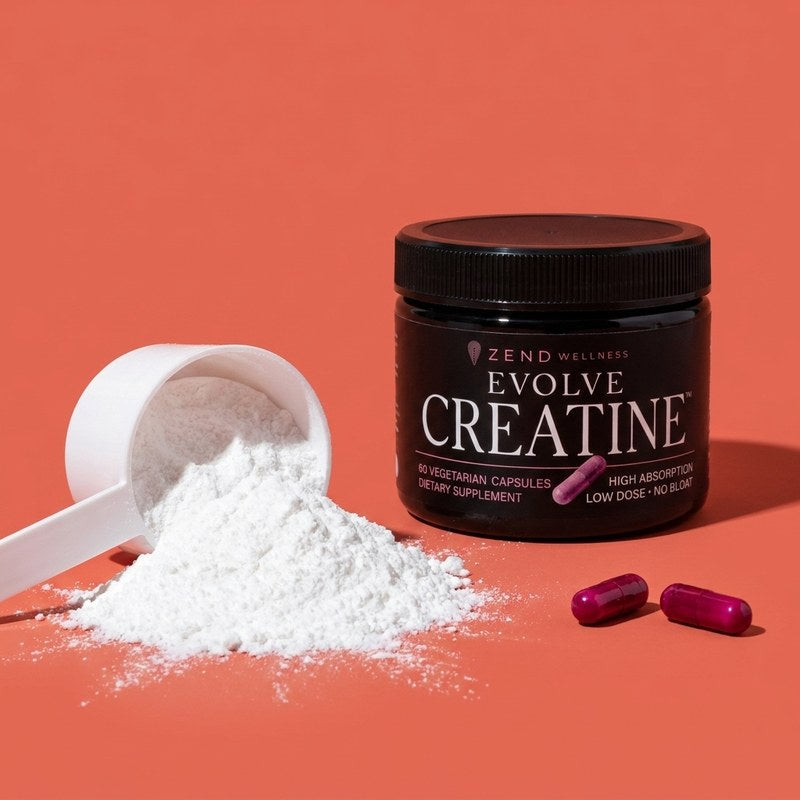 A five-gram mound of creatine powder and an oversized scoop beside two small Evolve capsules